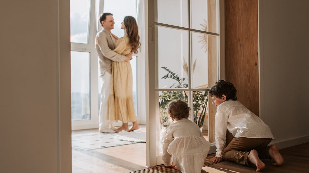 A joyful family moment indoors with parents and children enjoying a cozy home environment.