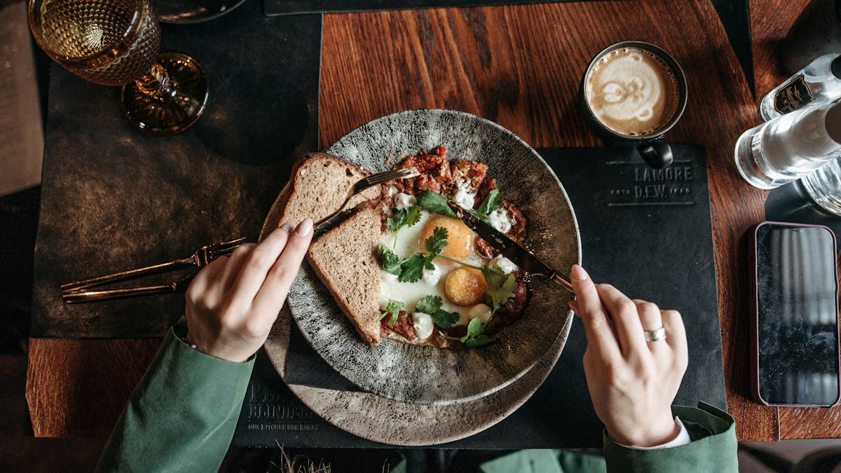 A fresh brunch scene with eggs, toast, and coffee on a rustic wooden table.